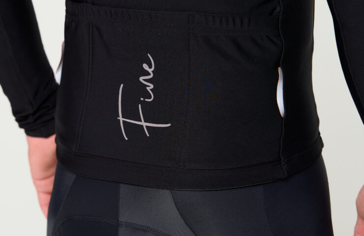 Zdjęcie z tyłu kolarza w czarnej bluzie i spodniach