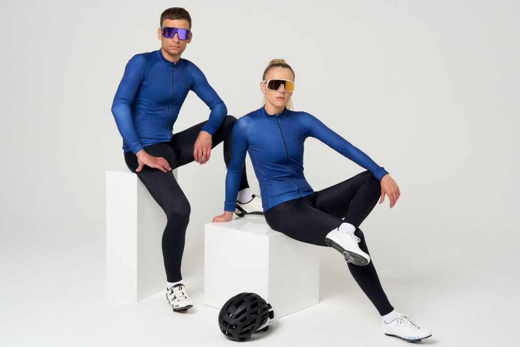 Kolarz i kolarka siedzą ubrani w odzież kolarską. bluza rowerowa